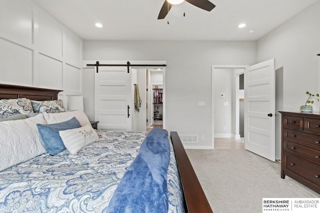 10317 S 191st Ave, Omaha, NE 68136 - bedroom featuring a barn door, light colored carpet, a spacious closet, recessed lighting, and a ceiling fan