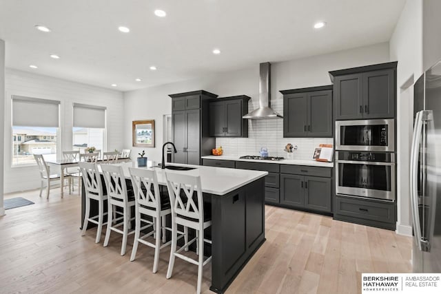 10317 S 191st Ave, Omaha, NE 68136 - kitchen with appliances with stainless steel finishes, wall chimney exhaust hood, a sink, light countertops, and decorative backsplash