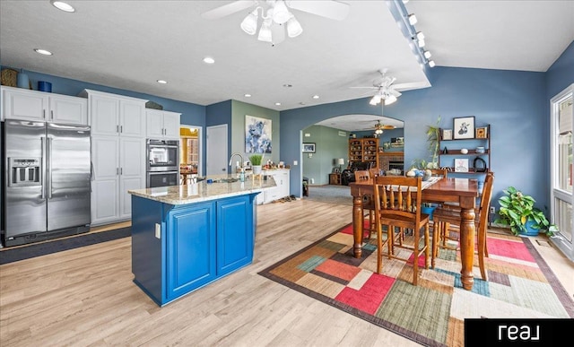 15102 Boyd St, Omaha, NE 68116 - kitchen featuring stainless steel appliances, a ceiling fan, arched walkways, light wood-style floors, and white cabinets