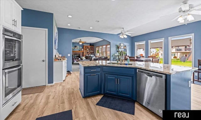 15102 Boyd St, Omaha, NE 68116 - kitchen with stainless steel appliances, ceiling fan, a sink, blue cabinets, and white cabinets