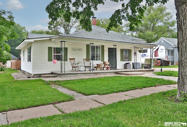 429 N 4th St, Tecumseh, NE 68450 - bungalow-style house featuring covered porch, a front yard, and a chimney