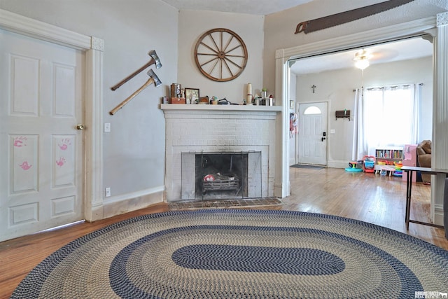 429 N 4th St, Tecumseh, NE 68450 - living room with wood finished floors, a brick fireplace, and baseboards