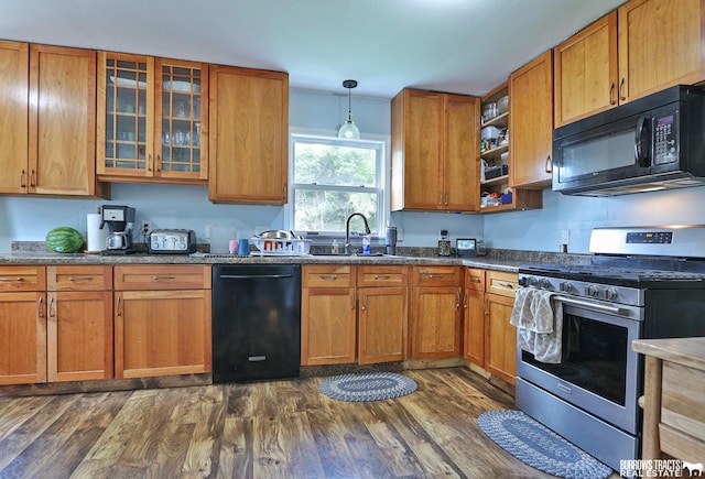429 N 4th St, Tecumseh, NE 68450 - kitchen with black appliances, a sink, dark wood-style floors, brown cabinets, and glass insert cabinets