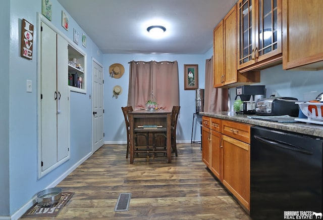 429 N 4th St, Tecumseh, NE 68450 - kitchen featuring black dishwasher, brown cabinetry, dark countertops, dark wood-type flooring, and glass insert cabinets