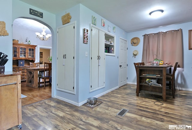 429 N 4th St, Tecumseh, NE 68450 - dining room featuring dark wood-style floors, arched walkways, a chandelier, and baseboards