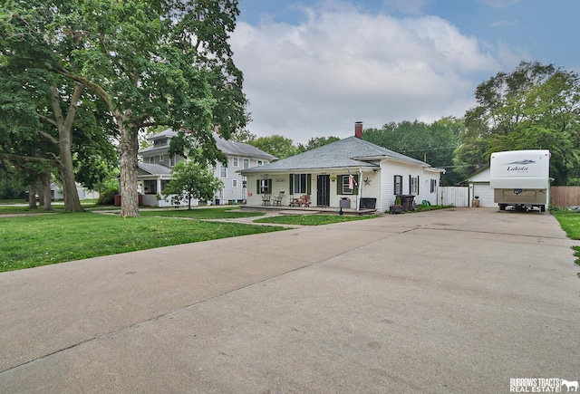 429 N 4th St, Tecumseh, NE 68450 - view of front of house featuring covered porch, a front yard, and a chimney