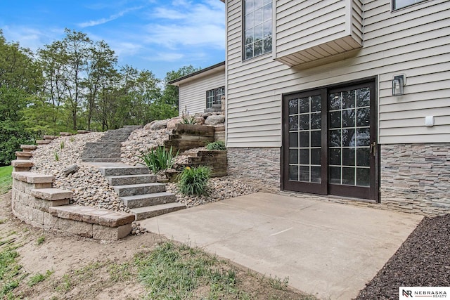 606 Pioneer Dr, Fort Calhoun, NE 68023 - doorway to property with stone siding and a patio