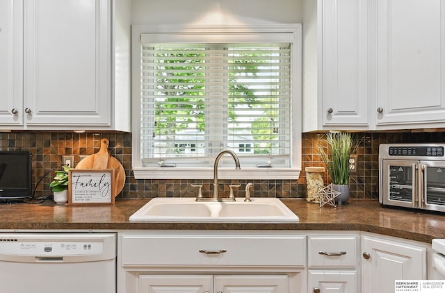 6641 S 85th St, Ralston, NE 68127 - kitchen featuring white dishwasher, a sink, white cabinets, dark countertops, and backsplash