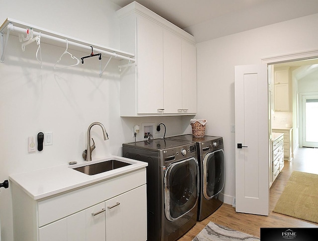 20640 Rawhide Rd, Omaha, NE 68022 - laundry area featuring washing machine and clothes dryer, cabinet space, light wood-style flooring, and baseboards