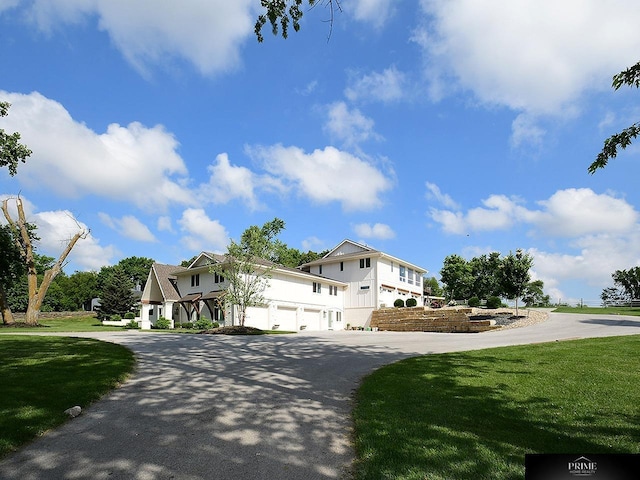 20640 Rawhide Rd, Omaha, NE 68022 - view of front of house with curved driveway, a garage, and a front lawn