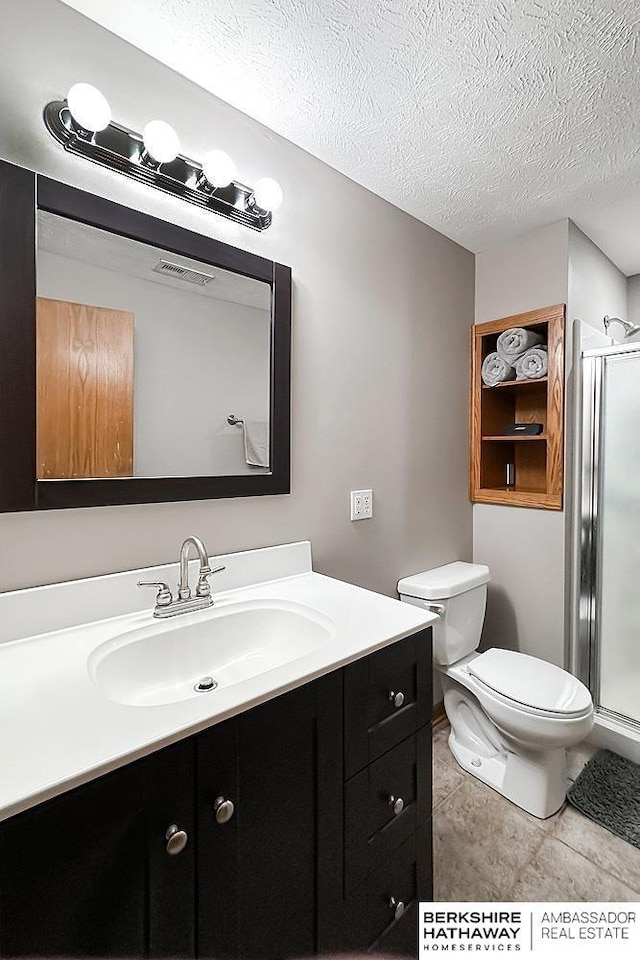 5360 S 174th Ave, Omaha, NE 68135 - bathroom featuring vanity, a stall shower, toilet, a textured ceiling, and tile patterned floors