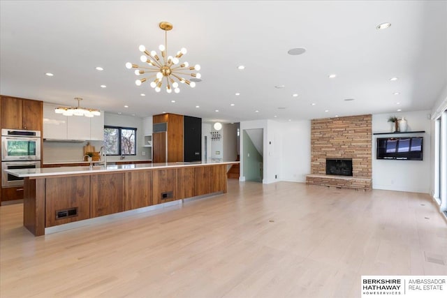 1312 S 78th St, Omaha, NE 68124 - kitchen featuring a chandelier, stainless steel double oven, modern cabinets, brown cabinets, and paneled built in refrigerator