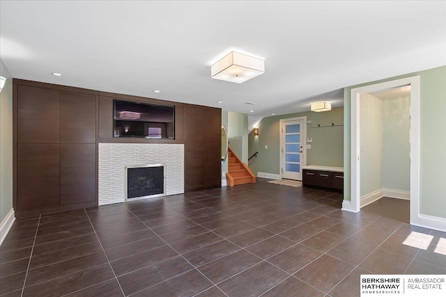 1312 S 78th St, Omaha, NE 68124 - unfurnished living room with baseboards, stairs, a fireplace, and dark tile patterned flooring