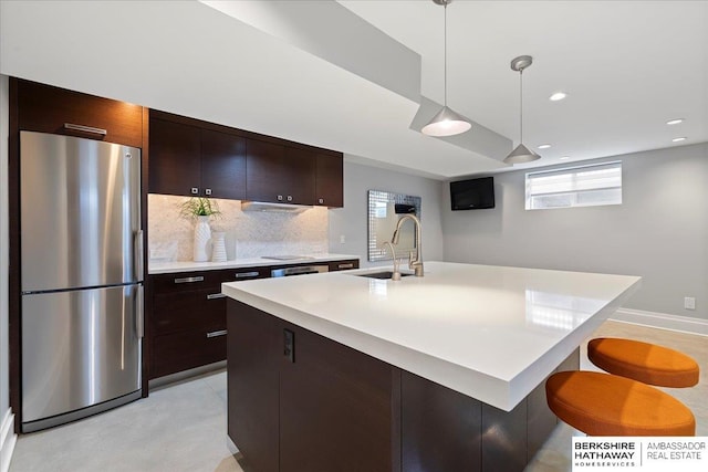 1312 S 78th St, Omaha, NE 68124 - kitchen with freestanding refrigerator, a sink, light countertops, decorative backsplash, and dark brown cabinets