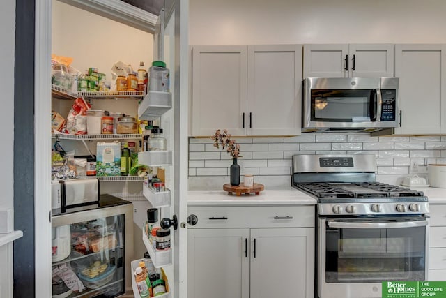 10505 Rosewater Pkwy, Bennington, NE 68007 - kitchen featuring appliances with stainless steel finishes, decorative backsplash, light countertops, and beverage cooler