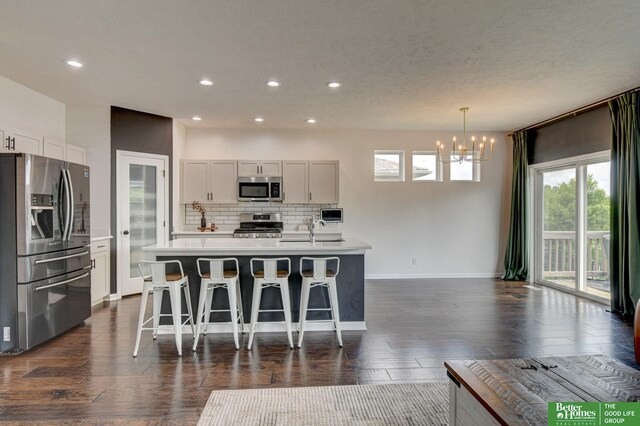 10505 Rosewater Pkwy, Bennington, NE 68007 - kitchen with stainless steel appliances, a chandelier, a sink, decorative backsplash, and light countertops