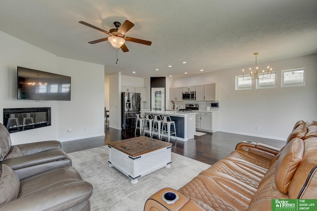 10505 Rosewater Pkwy, Bennington, NE 68007 - living area featuring a chandelier, baseboards, a ceiling fan, wood finished floors, and recessed lighting