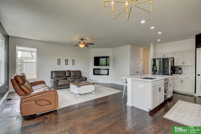 10505 Rosewater Pkwy, Bennington, NE 68007 - living area with dark wood-style flooring, recessed lighting, a ceiling fan, a chandelier, and baseboards