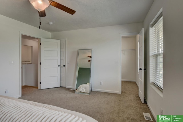 10505 Rosewater Pkwy, Bennington, NE 68007 - unfurnished bedroom with a walk in closet, carpet floors, a closet, and a ceiling fan