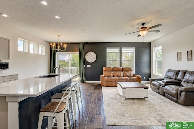 10505 Rosewater Pkwy, Bennington, NE 68007 - living area featuring a textured ceiling, recessed lighting, a chandelier, plenty of natural light, and dark wood-style flooring