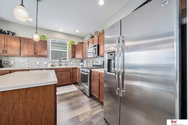 21327 Quarry Ln, Gretna, NE 68028 - kitchen featuring stainless steel appliances, wood finished floors, light countertops, tasteful backsplash, and hanging light fixtures