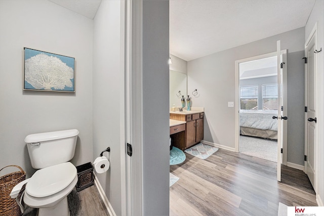 21327 Quarry Ln, Gretna, NE 68028 - bathroom featuring wood finished floors, vanity, toilet, baseboards, and connected bathroom
