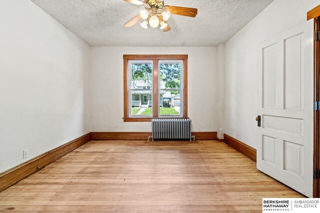 646 W 8th St, Fremont, NE 68025 - unfurnished room featuring radiator, a textured ceiling, ceiling fan, light wood-type flooring, and baseboards