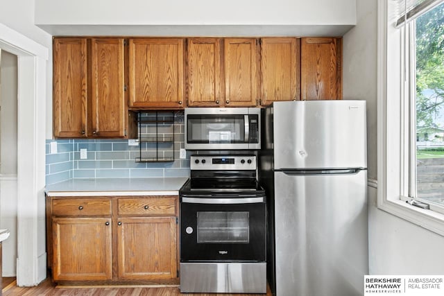 646 W 8th St, Fremont, NE 68025 - kitchen featuring stainless steel appliances, brown cabinets, light countertops, and backsplash