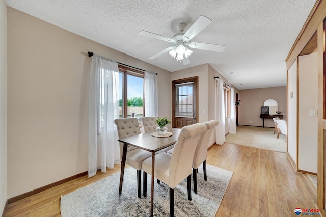 4321 S 58th St Unit 5, Lincoln, NE 68516 - dining space with light wood-type flooring, baseboards, a textured ceiling, and a ceiling fan