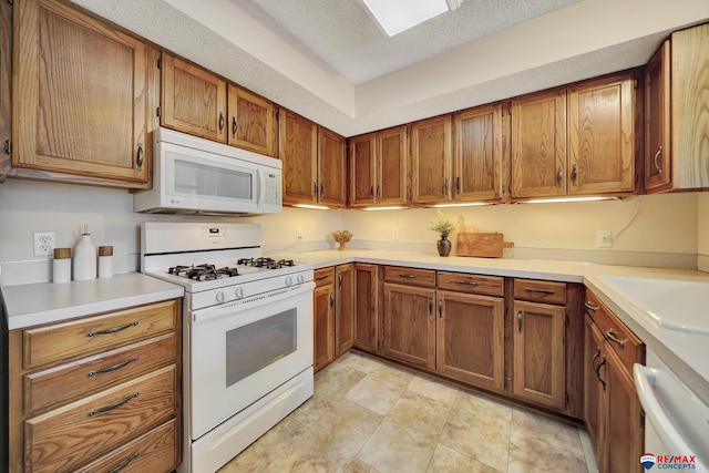4321 S 58th St Unit 5, Lincoln, NE 68516 - kitchen with white appliances, brown cabinets, light countertops, a textured ceiling, and a sink