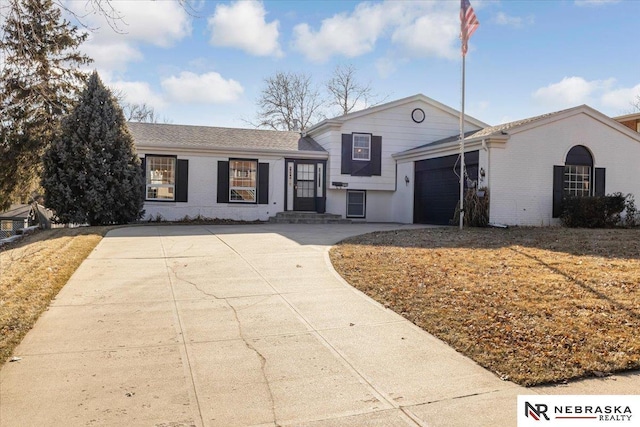 1615 S 136th St, Omaha, NE 68144 - tri-level home featuring brick siding, an attached garage, and driveway