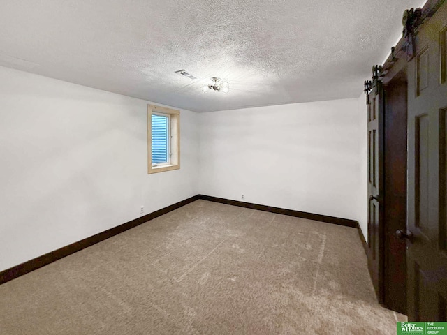 8259 Paradise Hills Ln, Fort Calhoun, NE 68023 - carpeted spare room featuring a textured ceiling, baseboards, and a barn door