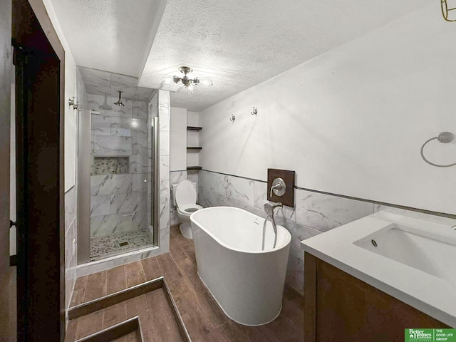 8259 Paradise Hills Ln, Fort Calhoun, NE 68023 - bathroom with a textured ceiling, a shower stall, a freestanding bath, vanity, and wood finished floors