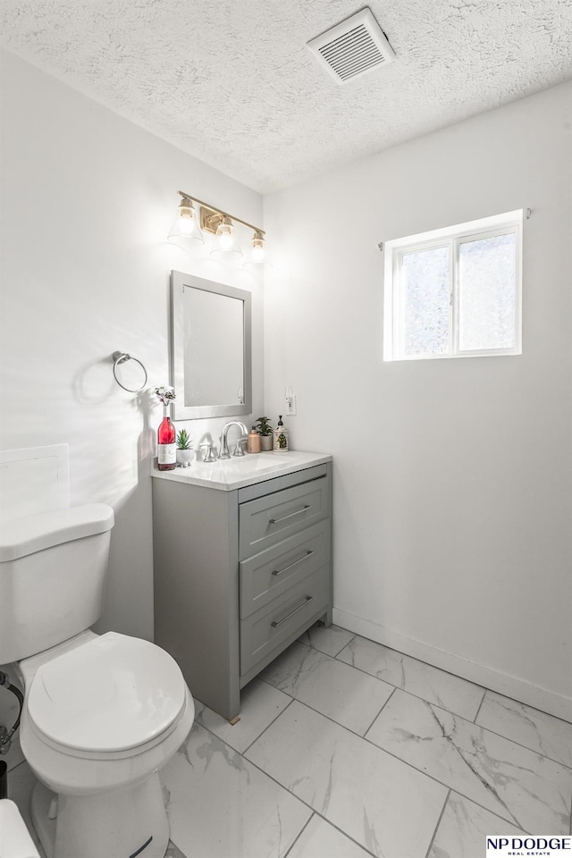 5335 N 26th St, Omaha, NE 68111 - bathroom featuring toilet, vanity, marble look tile flooring, and a textured ceiling