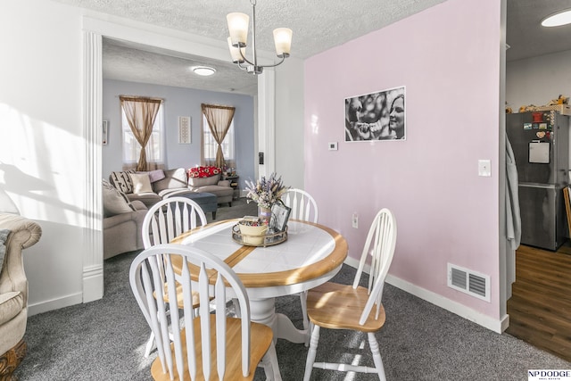 5335 N 26th St, Omaha, NE 68111 - dining room featuring a chandelier, a textured ceiling, and baseboards