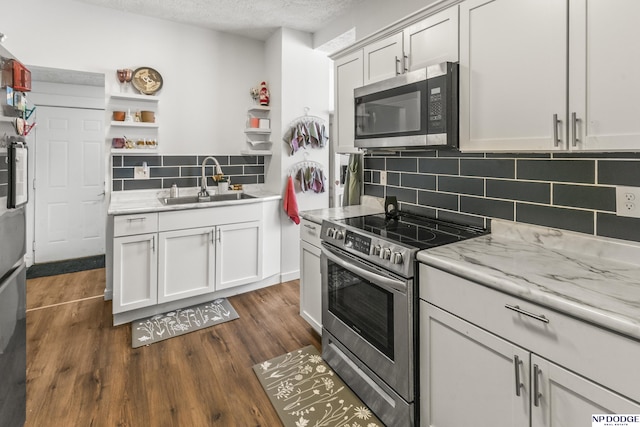 5335 N 26th St, Omaha, NE 68111 - kitchen featuring appliances with stainless steel finishes, a sink, open shelves, tasteful backsplash, and dark wood-style floors