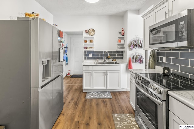 5335 N 26th St, Omaha, NE 68111 - kitchen with appliances with stainless steel finishes, a sink, open shelves, decorative backsplash, and a textured ceiling