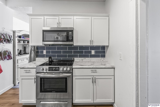 5335 N 26th St, Omaha, NE 68111 - kitchen with appliances with stainless steel finishes, wood finished floors, backsplash, light stone counters, and white cabinets