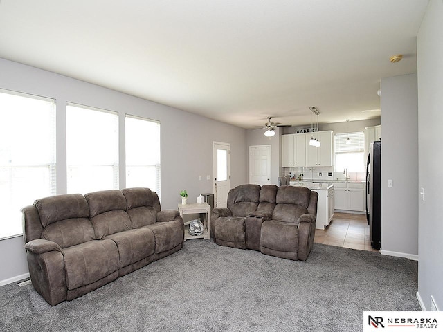 7941 N 152nd St, Bennington, NE 68007 - living room featuring light colored carpet, ceiling fan, baseboards, and light tile patterned floors