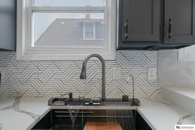 2306 Ogden St, Omaha, NE 68110 - kitchen view of tasteful backsplash, a sink, and light stone countertops