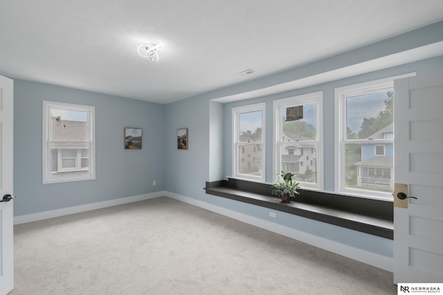 2306 Ogden St, Omaha, NE 68110 - empty room with healthy amount of natural light, carpet flooring, and baseboards