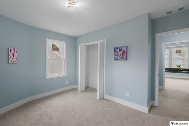 2306 Ogden St, Omaha, NE 68110 - unfurnished bedroom featuring light colored carpet, multiple windows, and baseboards