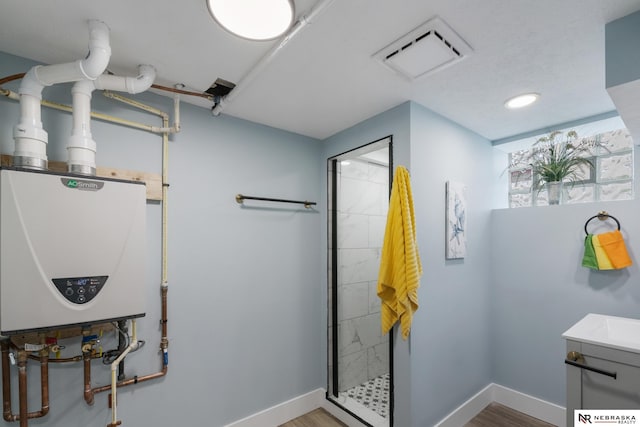 2306 Ogden St, Omaha, NE 68110 - bathroom with tankless water heater, a shower stall, baseboards, vanity, and wood finished floors