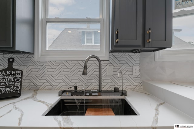 2306 Ogden St, Omaha, NE 68110 - kitchen featuring a sink, tasteful backsplash, and light stone countertops
