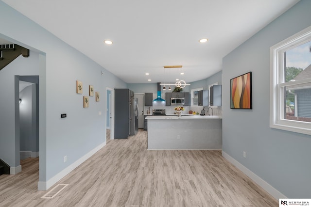 2306 Ogden St, Omaha, NE 68110 - kitchen featuring appliances with stainless steel finishes, light wood-style floors, light countertops, a peninsula, and recessed lighting