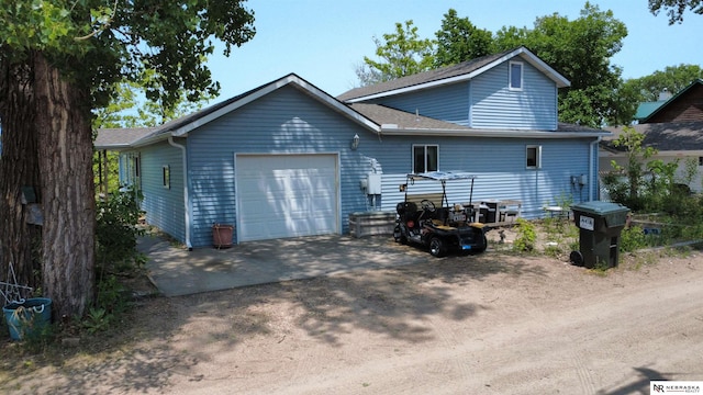 35 E Sandy Ridge Rd, Columbus, NE 68601 - view of front facade featuring an attached garage, dirt driveway, and roof with shingles
