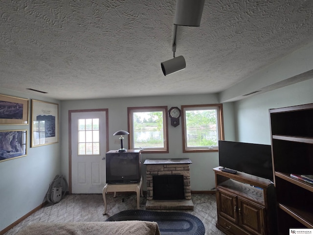 35 E Sandy Ridge Rd, Columbus, NE 68601 - living room featuring a textured ceiling, baseboards, and a fireplace