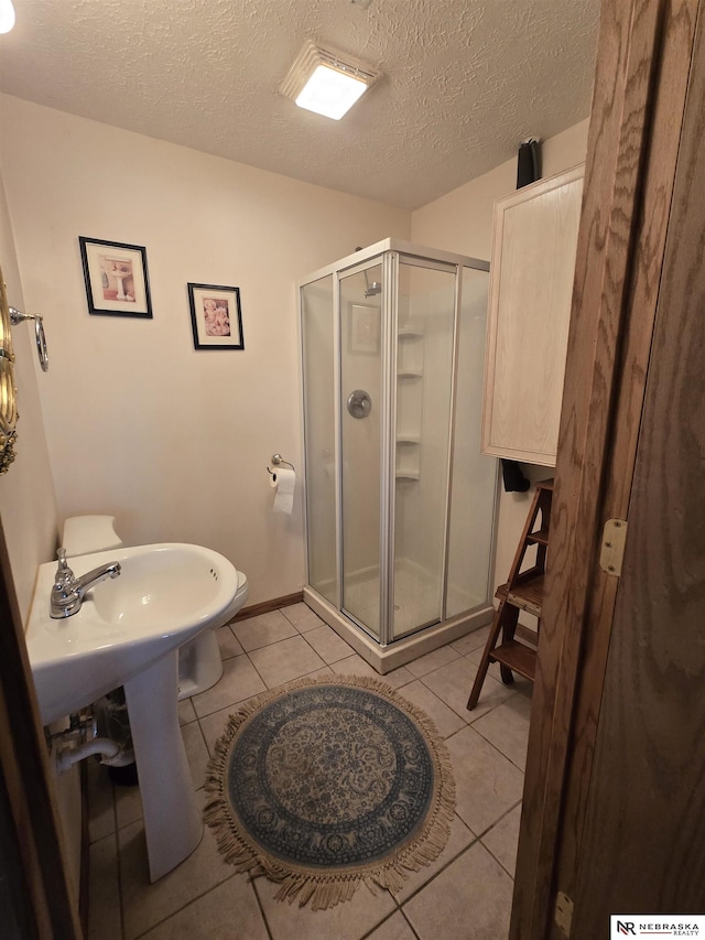 35 E Sandy Ridge Rd, Columbus, NE 68601 - full bath with a stall shower, tile patterned floors, and a textured ceiling