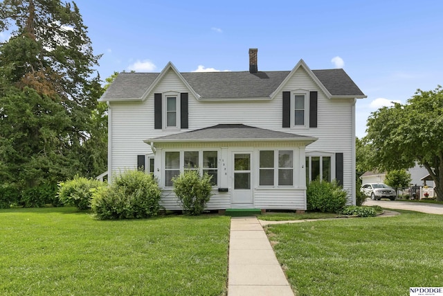 1373 S St, Blair, NE 68008 - traditional-style home featuring a chimney, roof with shingles, a front yard, and a sunroom