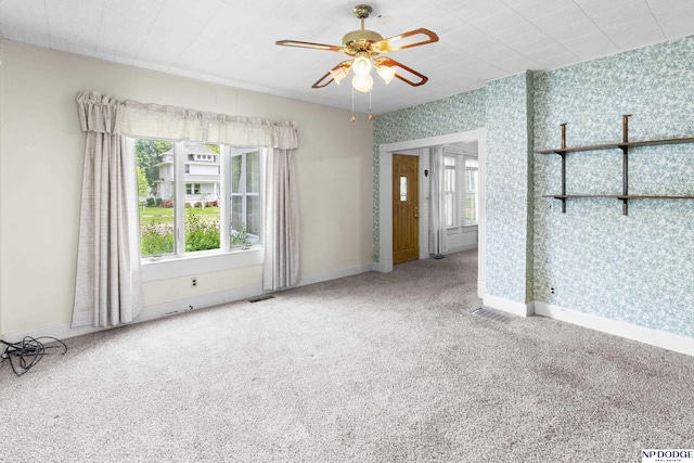 1373 S St, Blair, NE 68008 - unfurnished room featuring plenty of natural light, ceiling fan, baseboards, carpet, and wallpapered walls